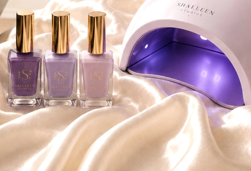 Gel polish bottles and a nail lamp on satin
